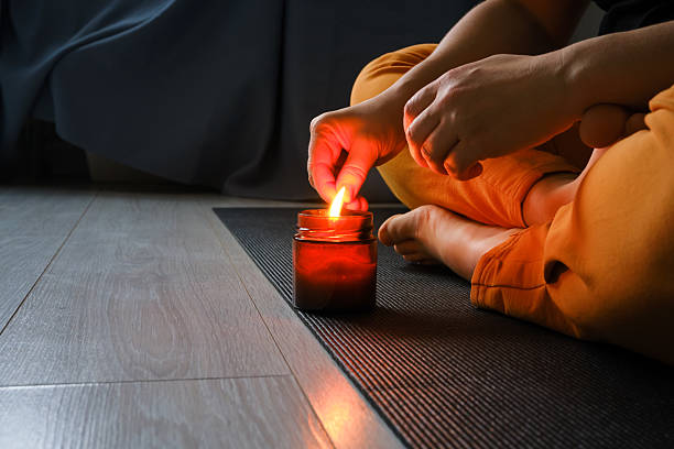 Single candle flame in a darkened room for meditation
