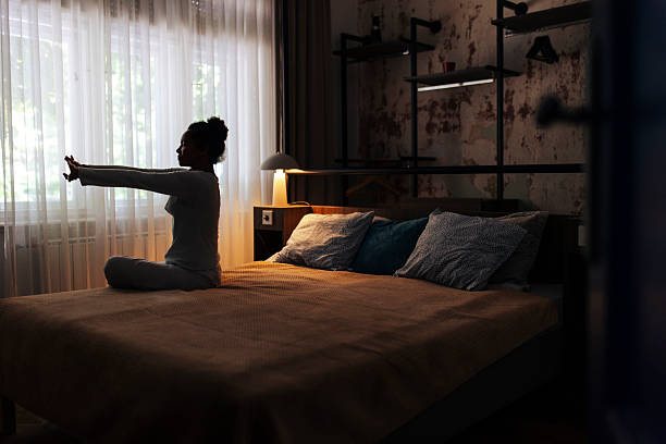 Person practising calm breathing in a dimly lit bedroom